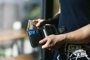 Persona sacando dinero de su billetera